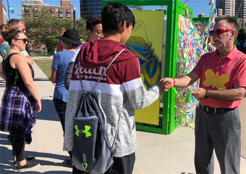 Visitors adding ribbons to Broken Wings installation