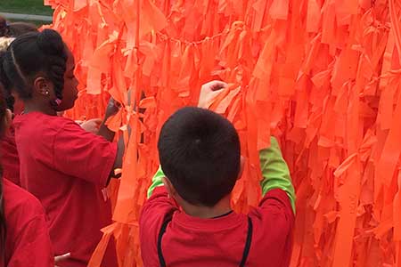 Ribbons being tied on the Color Me Orange&mdash;Color Me Kind installation