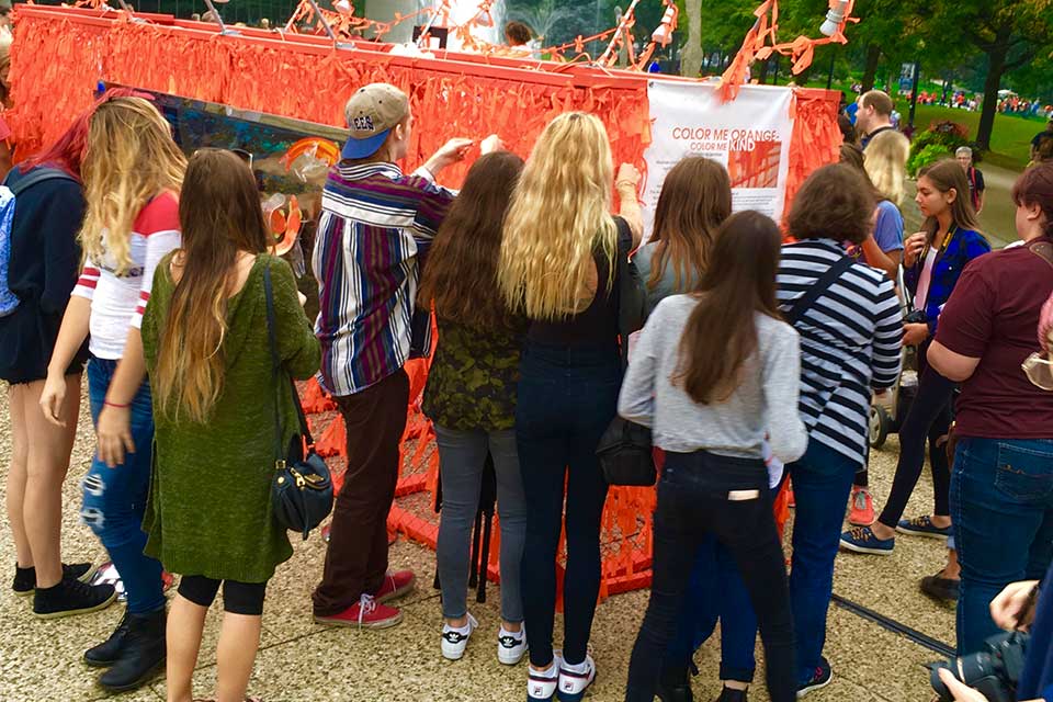 A group of youth tying ribbons on Color Me Orange&mdash;Color Me Kind
