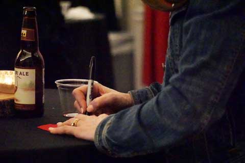 Participant writing on red denim